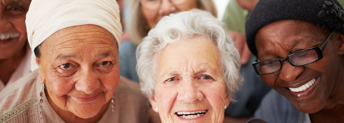 A group of seniors smiling together while in a retirement home